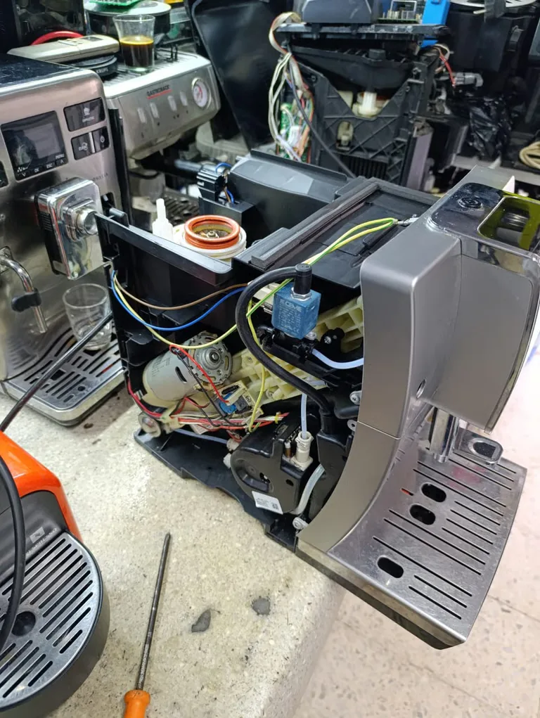 Machine à café ouverte sur l’établi pendant une intervention