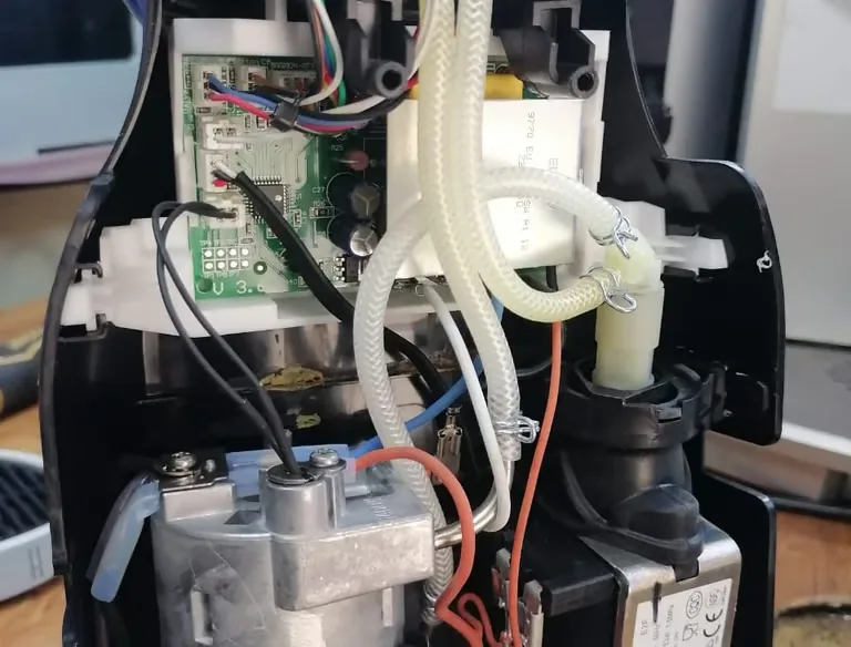 Intérieur d’une machine à café ouverte : circuit hydraulique et carte électronique